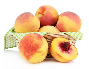 Ripe sweet peaches in wicker basket, isolated on white