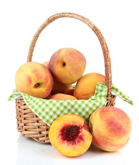 Ripe sweet peaches in wicker basket, isolated on white
