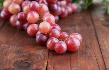 Ripe purple grapes on wooden table close-up