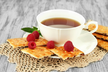 Cup of tea with cookies and raspberries on table close-up