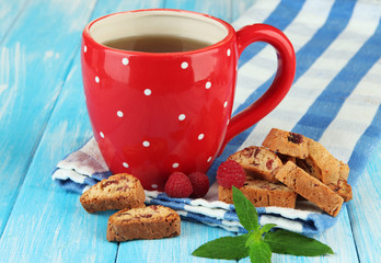 Cup of tea with cookies and raspberries on table close-up