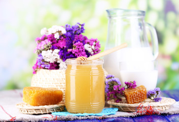 Obraz na płótnie Canvas Honey and milk on wooden table on natural background