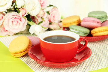 Coffee and macaroons on table on light background