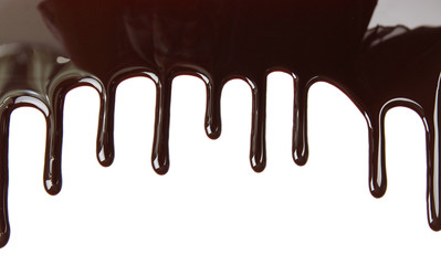 Melted chocolate dripping on white background