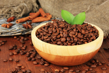 Coffee beans in bowl on wooden background