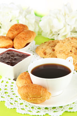 Tasty croissants and cup of coffee on table close-up