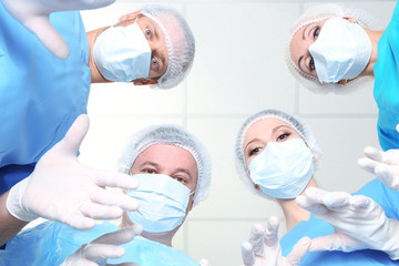 View from below of surgeons in protective work wear during