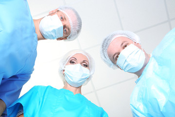 View from below of surgeons in protective work wear during