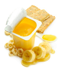 Tasty dessert in open plastic cup and banana, isolated on white