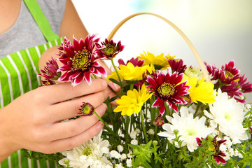 Obraz na płótnie Canvas Florist makes flowers bouquet in wicker basket
