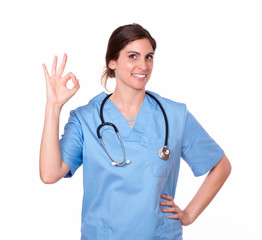 Fototapeta premium Hispanic lady nurse smiling with ok finger sign