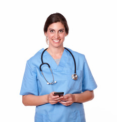 Lovely young nurse smiling sending a text
