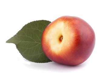 Nectarine with green leaf on a white background.