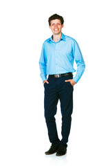 Fototapeta premium Happy young businessman standing with his hands in pockets on wh