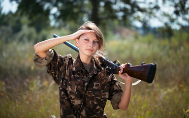 Fototapeta premium Young beautiful girl with a shotgun outdoor