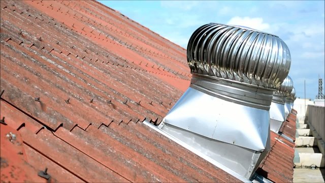 Row of spinning wind ventilators on old tiled roof [HD]