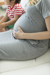 ソファに座る妊婦と少年