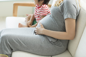 ソファに座る妊婦と少年