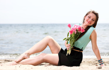 young beautiful woman portrait on the beach bunch flower