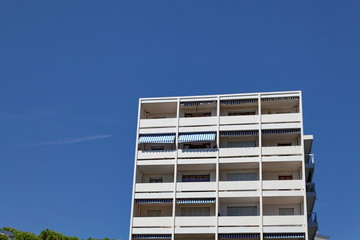 Immeuble blanc avec stores ciel bleu