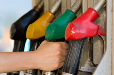 Hand holds fuel nozzle in petroleum station