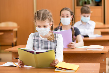 Fototapeta na wymiar school kids with protection mask against flu virus at lesson