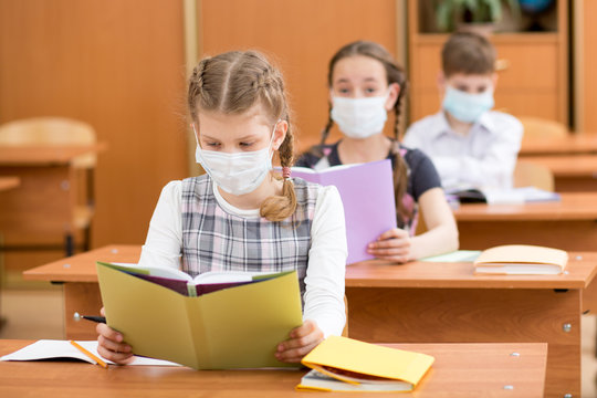 School Kids With Protection Mask Against Flu Virus At Lesson