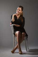 Portrait of beautiful woman sitting on chair in studio