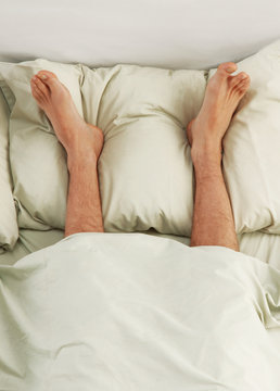 Pies sobre la cama,descansando los pies.