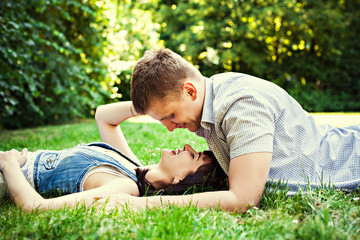 Naklejka na ściany i meble Happy couple lying on grass