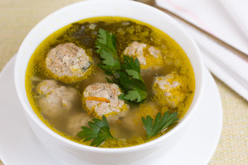 Plate of vegetable soup with meatballs