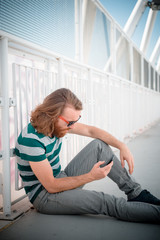 stylish hipster model with long red hair and beard lifestyle on