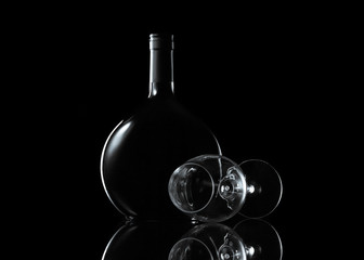 Bottle and glass of wine on black background