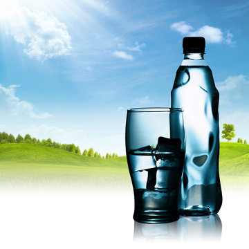 Spring mineral water bottled with glass and ice against natural