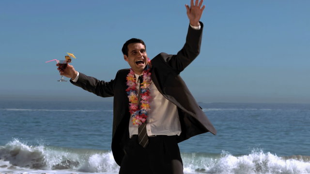 Attractive businessman dancing on the beach