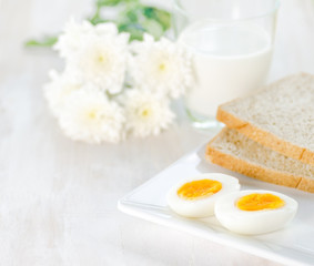 Boiled eggs, toasts and glass of milk