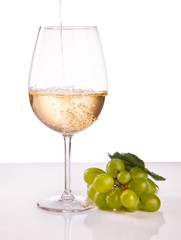 wineglass with white wine and grape isolated on white background