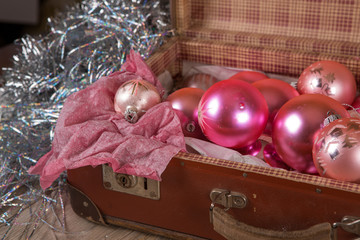 Ancient pink Christmas tree toys in antique suitcase