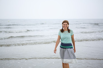 Fototapeta na wymiar Young happy woman walking on the beach of St.Peter Ording, North