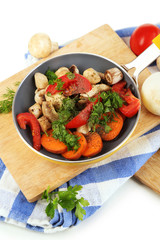 Sliced fresh vegetables in pan on wooden board isolated on