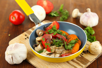 Sliced fresh vegetables in pan on wooden table close-up