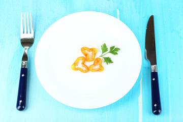 Small portion of food on big plate on wooden table close-up