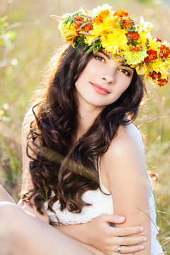 Closeup portrait of beautiful young woman with flower wreath
