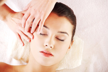 Obraz na płótnie Canvas Beautiful young relaxed woman enjoy receiving face massage