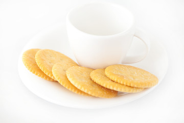 white cup with saucer and crackers