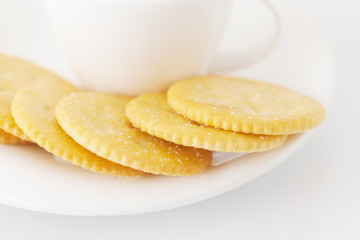 white cup with saucer and crackers