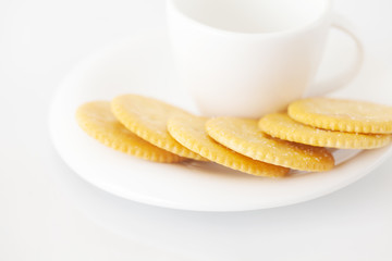 white cup with saucer and crackers