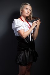 Folk woman in folklore clothes braiding a plait