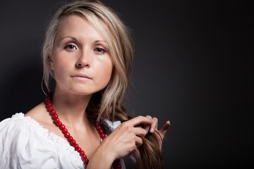 Obraz premium Folk woman in folklore clothes braiding a plait