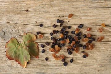 Golden and black raisins over wooden table